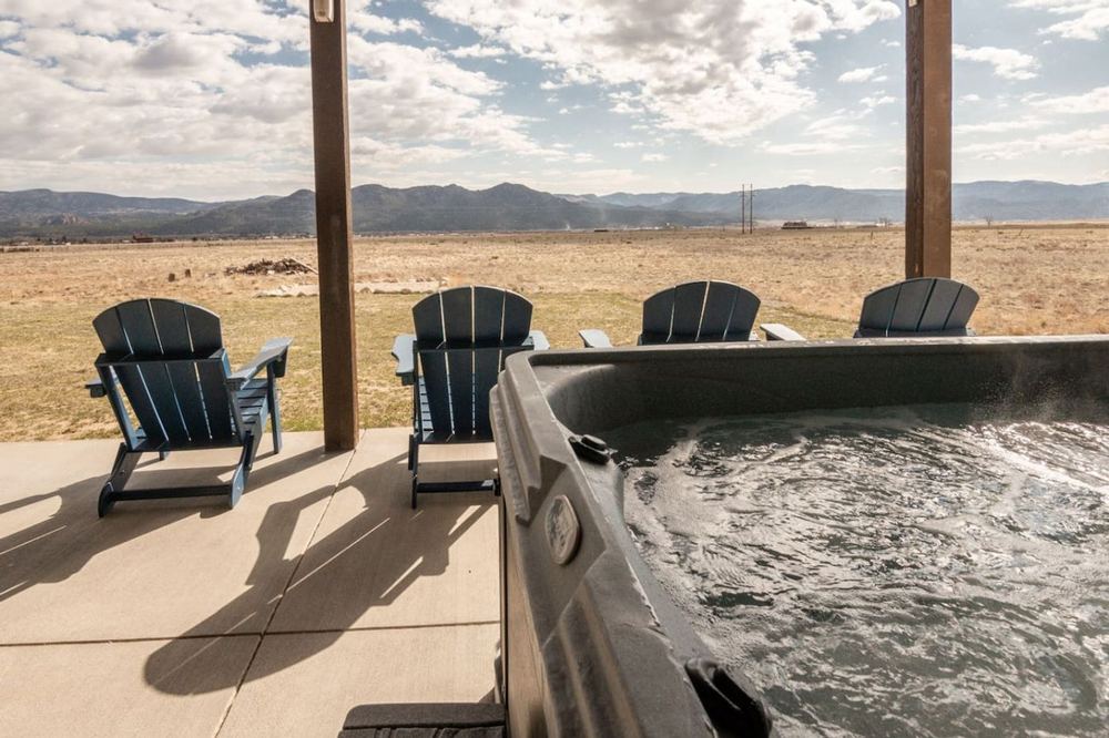 Hot tub and covered deck with mountain views at a short-term rental in Buena Vista, Colorado